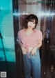 A woman standing in front of a glass shower door.