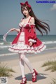 A woman in a red and white dress standing on a beach.