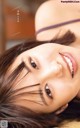 A woman with long brown hair laying on a bed.