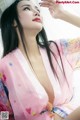 A woman in a pink kimono is posing for a picture.