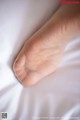 A close up of a person's foot on a bed.