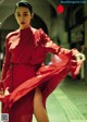 A woman in a red dress is walking down the street.