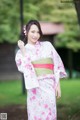 A woman in a pink and green kimono posing for a picture.