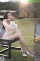 A woman sitting on a chair eating an apple.