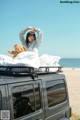 A woman sitting on top of a bed with a teddy bear.