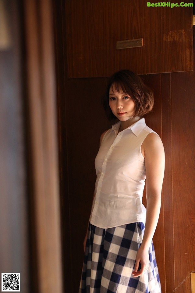 A woman standing in front of a wooden door.