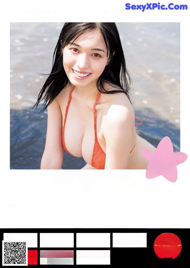 A woman in a red bikini posing in the water.