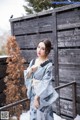 A woman in a blue kimono standing in the snow.