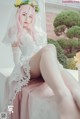 A woman in a wedding dress sitting on a window sill.