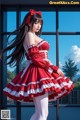 A woman in a red and white dress posing for a picture.