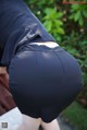 A woman in a black skirt is bending over on a bench.