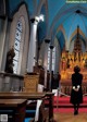 A woman standing in front of a church altar.