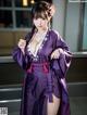 A woman in a purple kimono posing for a picture.