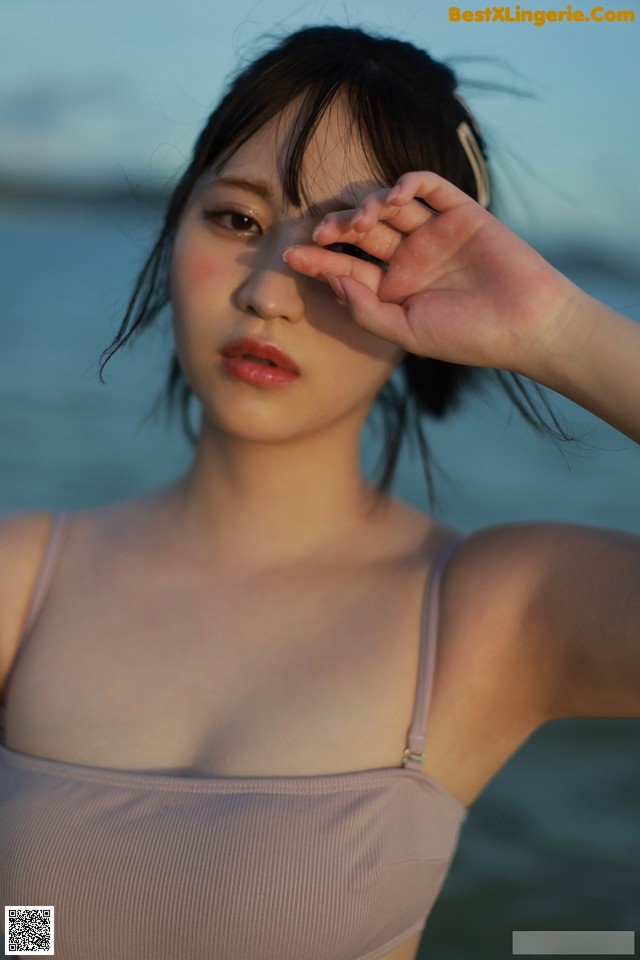 A woman in a pink bikini standing on a beach.
